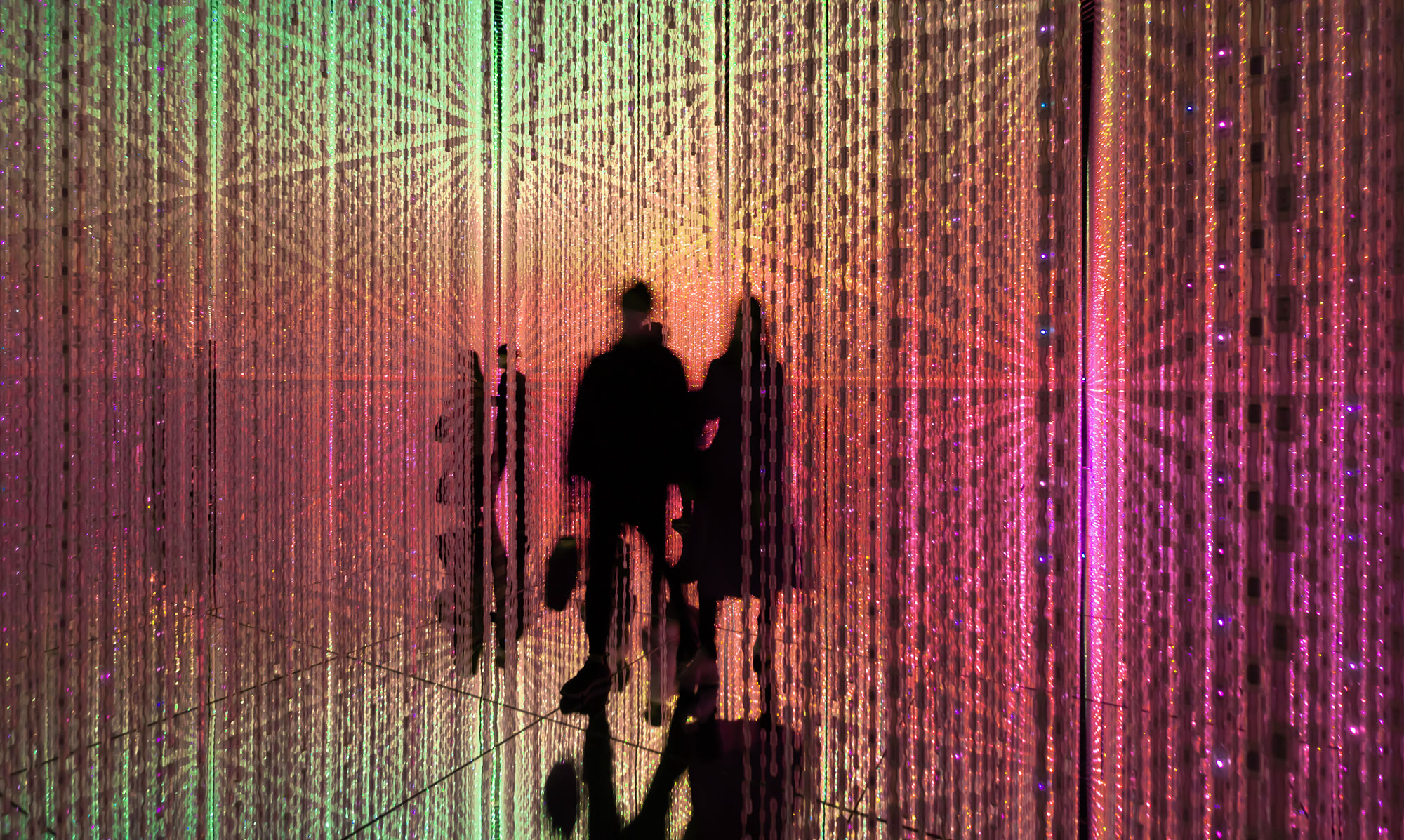 shadows of people walking through a rainbow prism 